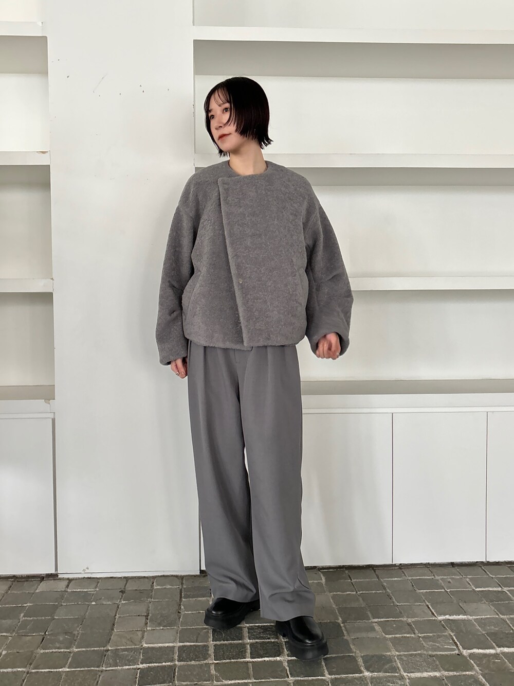 グレー系のブルゾン、グレー系のその他パンツ、ブラック系のブーツを着用したレディースの秋コーディネートの6枚目の写真