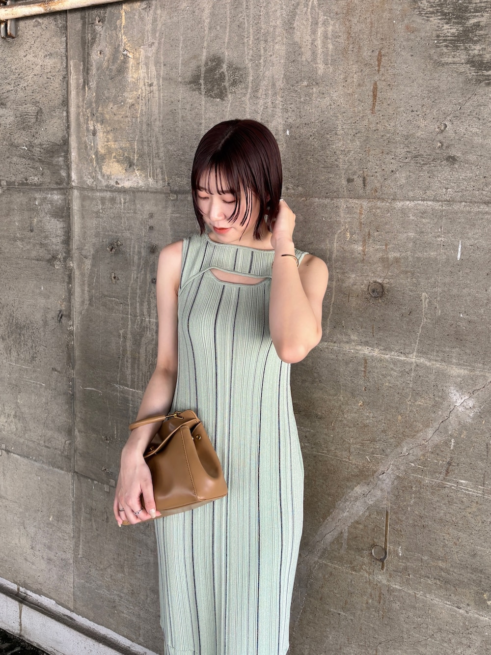 グリーン系のワンピース、ブラック系のサンダル、イエロー系のハンドバッグを着用したレディースの春コーディネートの5枚目の写真