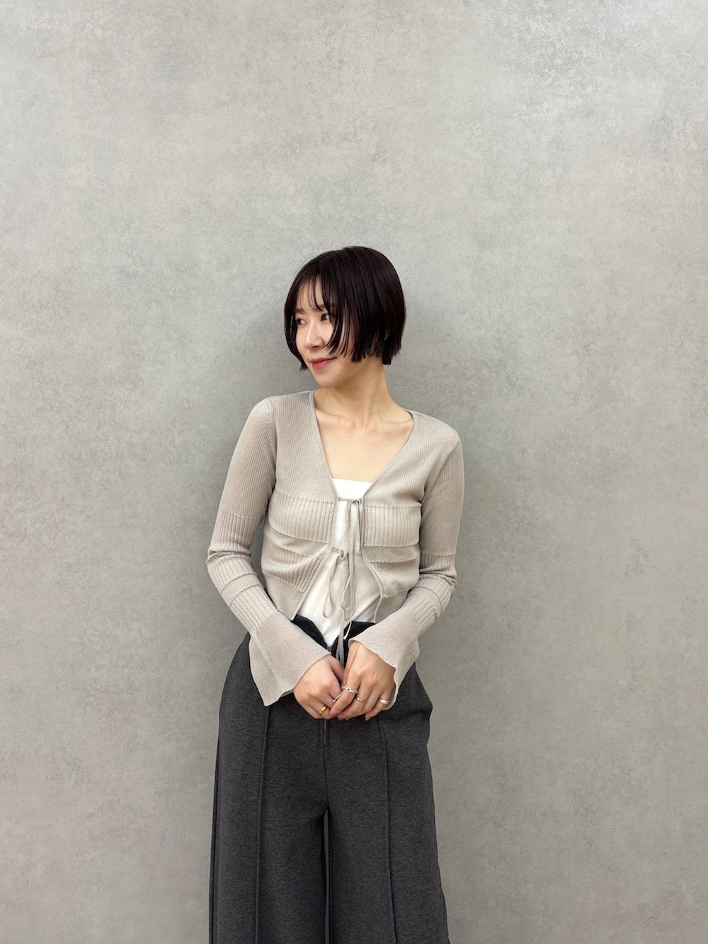 グレー系のスウェットパンツ、グレー系のカーディガン/ボレロ、ホワイト系のチューブトップを着用したレディースの春コーディネートの5枚目の写真