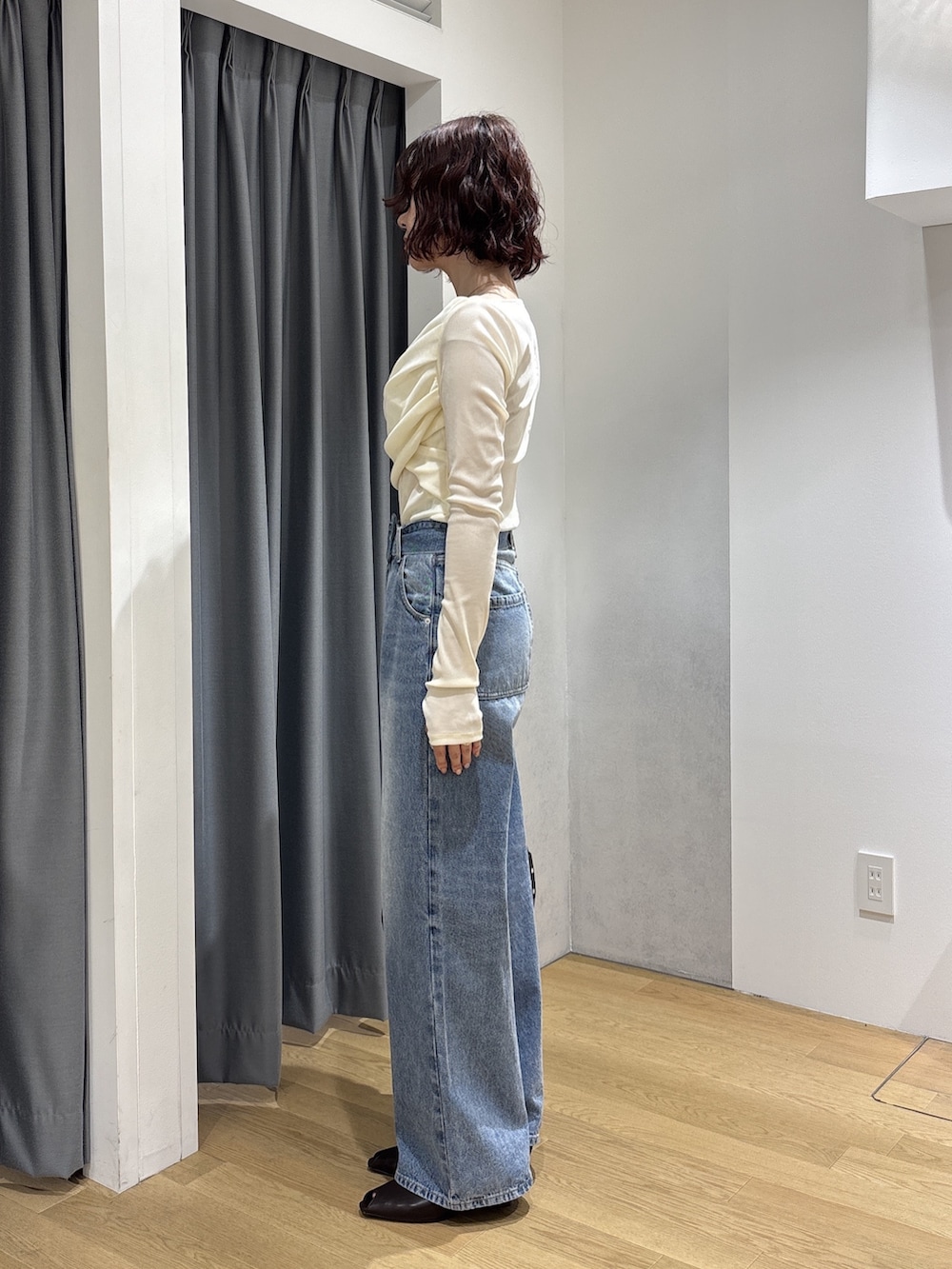 ホワイト系のTシャツ/カットソー、ブルー系のデニムパンツ、ブラック系のハンドバッグを着用したレディースの秋コーディネートの3枚目の写真