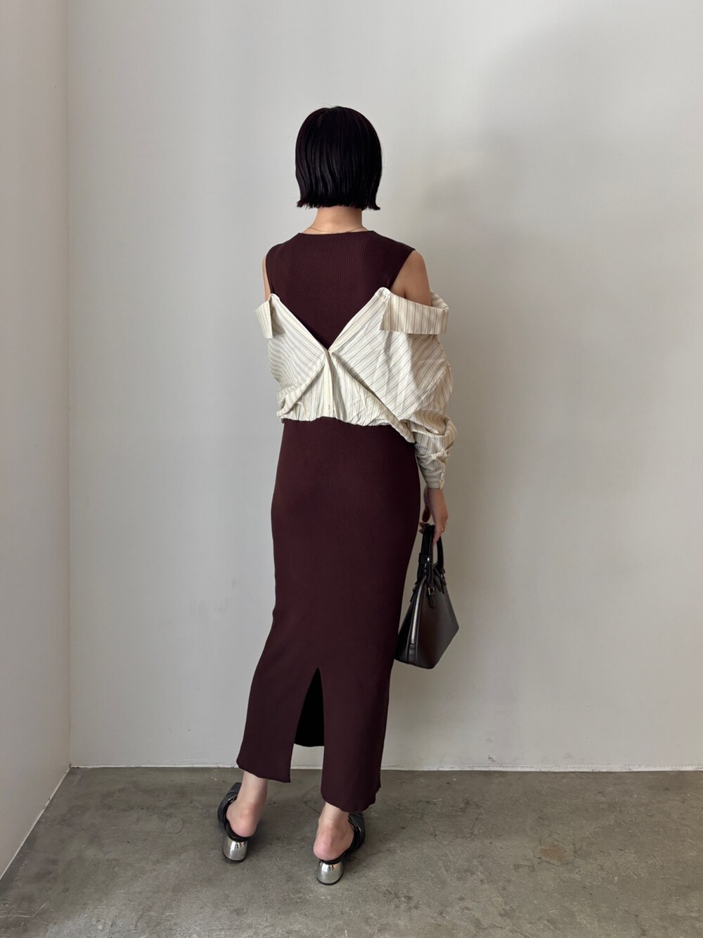 ブラウン系のワンピース、ブラウン系のボストンバッグ、ブラウン系のパンプスを着用したレディースの秋コーディネートの4枚目の写真