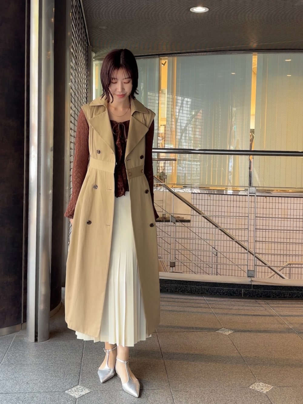 ブラウン系のシャツ/ブラウス、ベージュ系のトレンチコート、ブラウン系のハンドバッグを着用したレディースの冬コーディネートの6枚目の写真