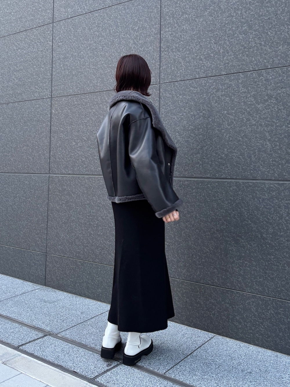 ブラック系のワンピース、グレー系のムートンコートを着用したレディースの冬コーディネートの6枚目の写真