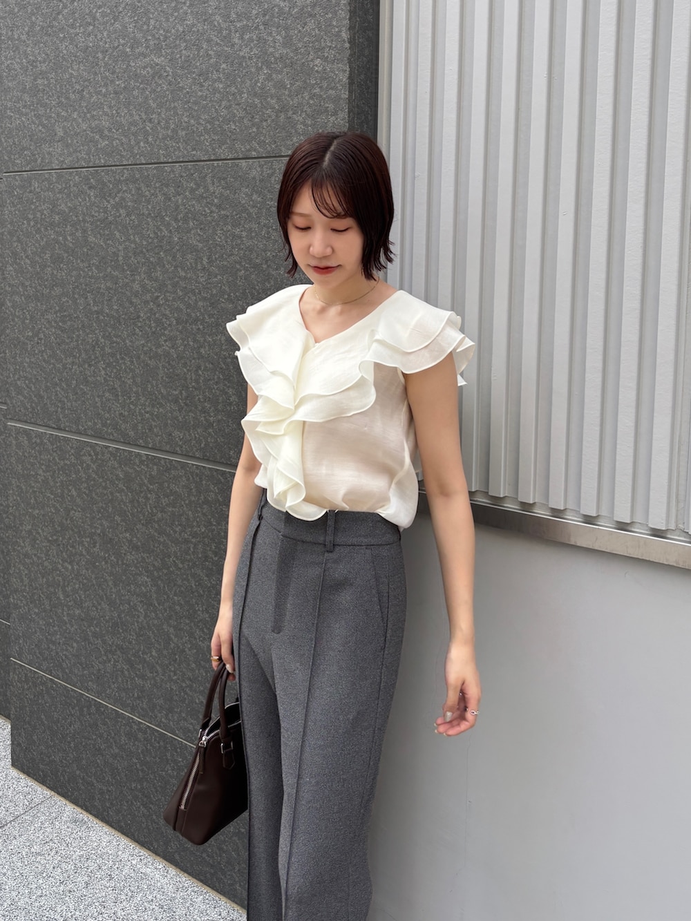 グレー系のその他パンツ、ホワイト系のシャツ/ブラウス、ブラウン系のボストンバッグを着用したレディースの夏コーディネートの5枚目の写真
