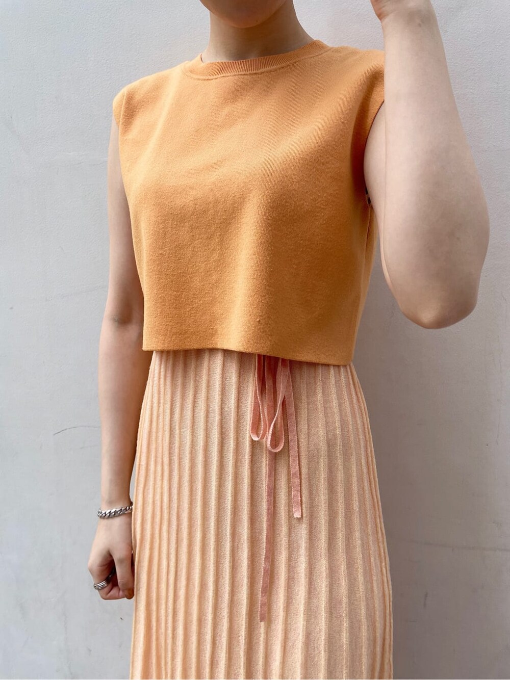 ホワイト系のテーラードジャケット、オレンジ系のワンピースを着用したレディースの春コーディネートの6枚目の写真