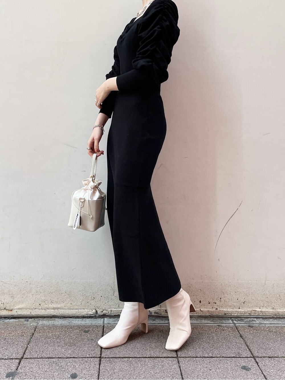 ブラック系のワンピース、ホワイト系のハンドバッグ、ホワイト系のその他シューズを着用したレディースの冬コーディネートの3枚目の写真