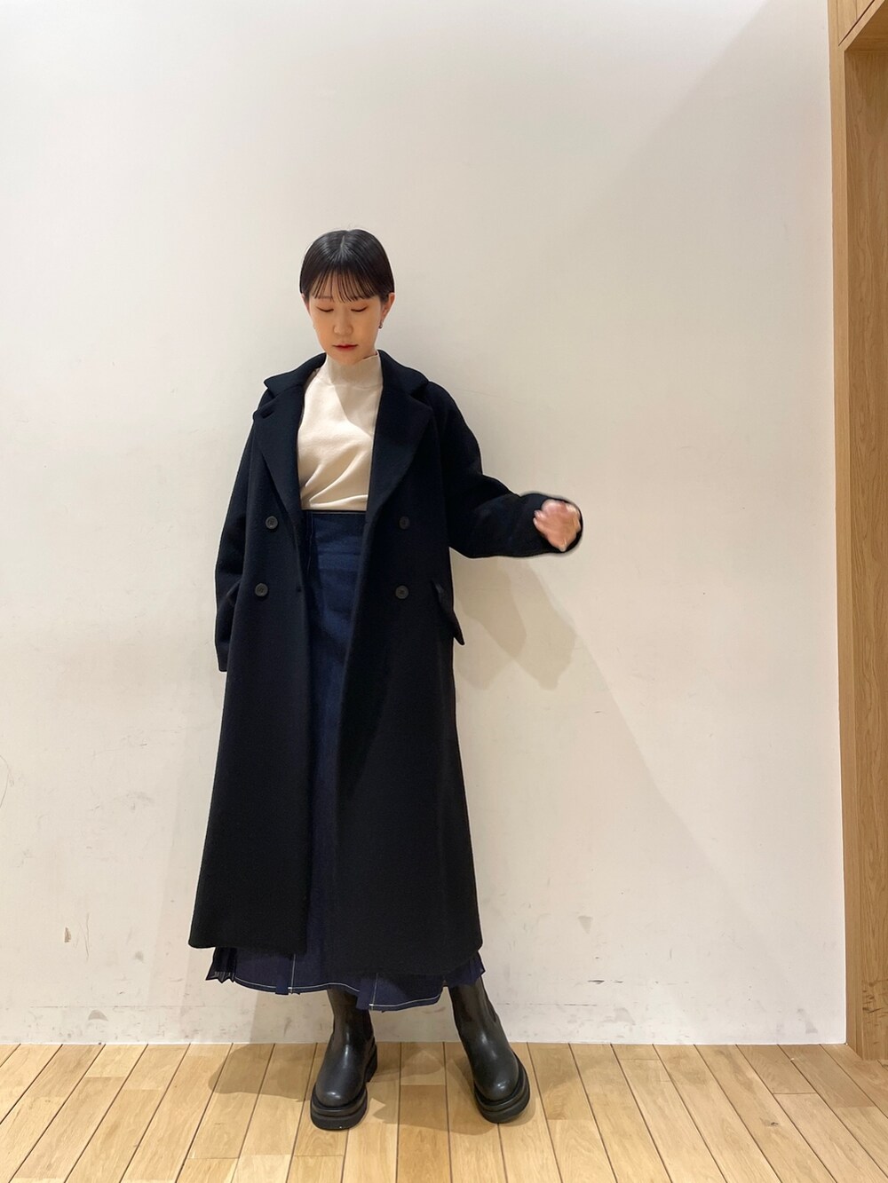 ブラック系のその他アウター、ホワイト系のニット/セーター、ブルー系のスカートを着用したレディースの冬コーディネートの3枚目の写真