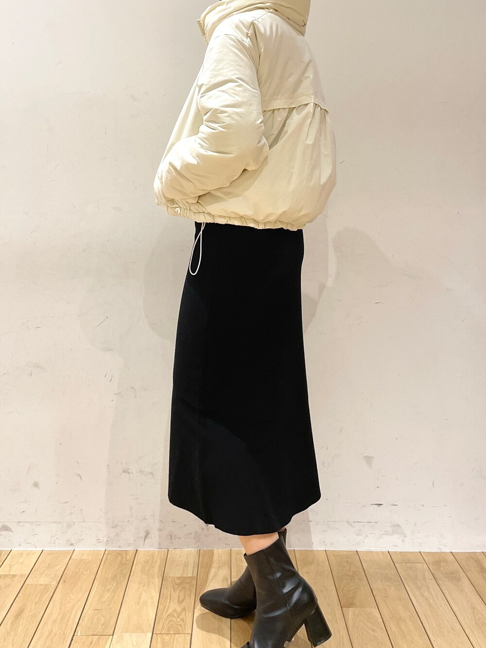 ブラック系のスカート、グレー系のニット/セーター、ブラック系のブーツを着用したレディースの冬コーディネートの7枚目の写真