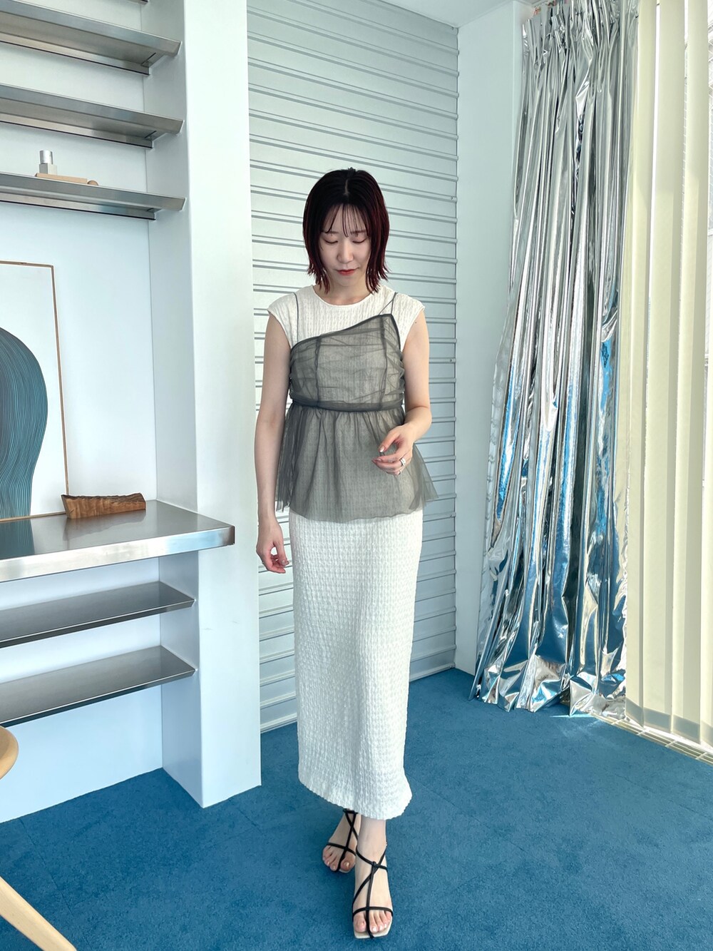 ブラック系のサンダル、ホワイト系のワンピースを着用したレディースの夏コーディネートの2枚目の写真