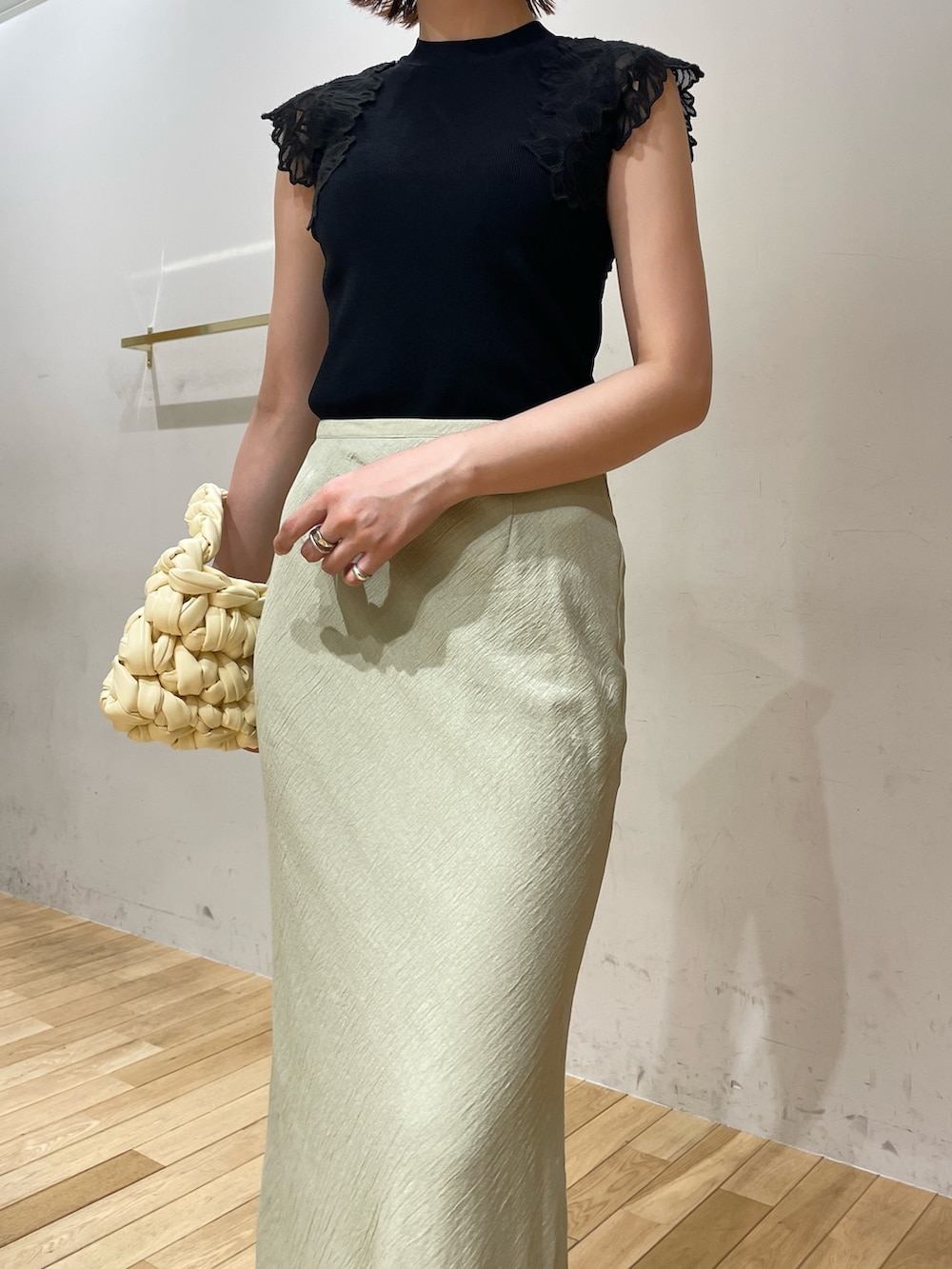 ベージュ系のハンドバッグ、ブラック系のサンダル、グリーン系のスカートを着用したレディースの夏コーディネートの6枚目の写真