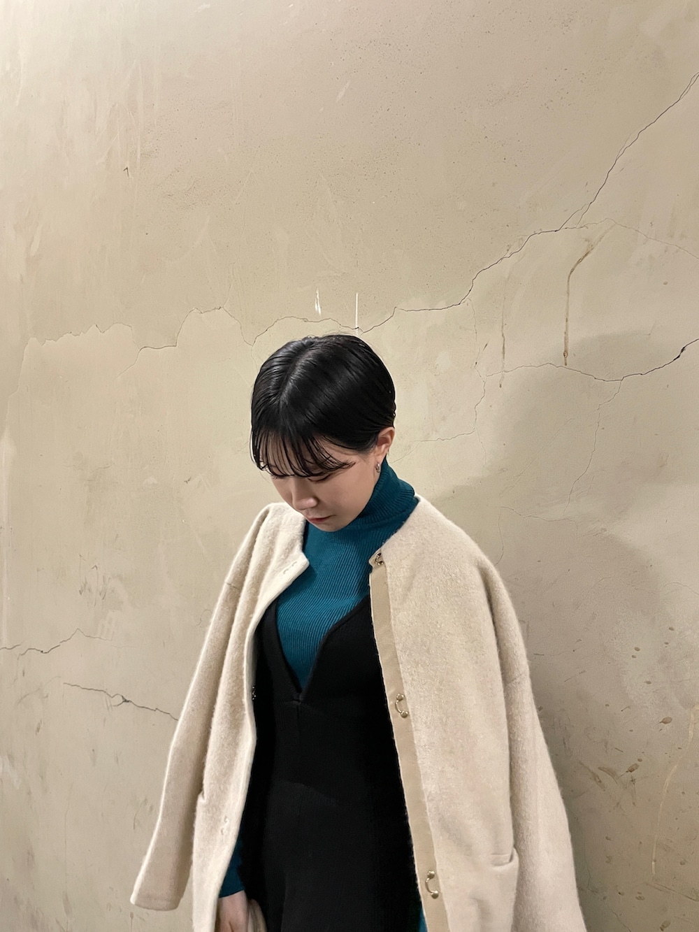 ブラック系のスカート、グリーン系のニット/セーター、ブラック系のブーツを着用したレディースの秋コーディネートの7枚目の写真