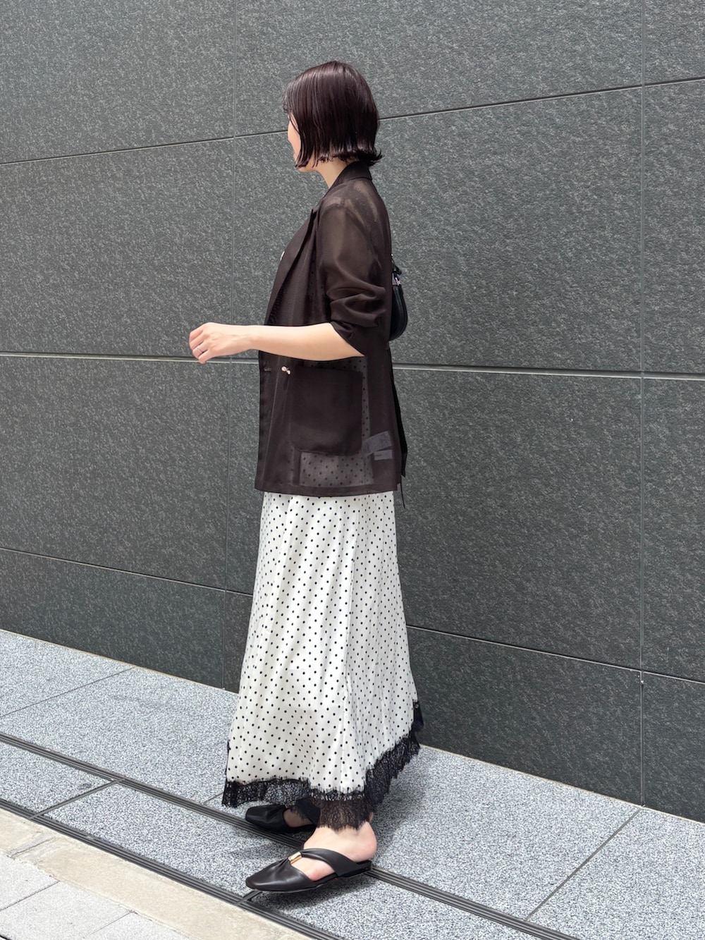 ホワイト系のワンピース、ブラック系のハンドバッグ、ブラウン系のサンダルを着用したレディースの夏コーディネートの8枚目の写真