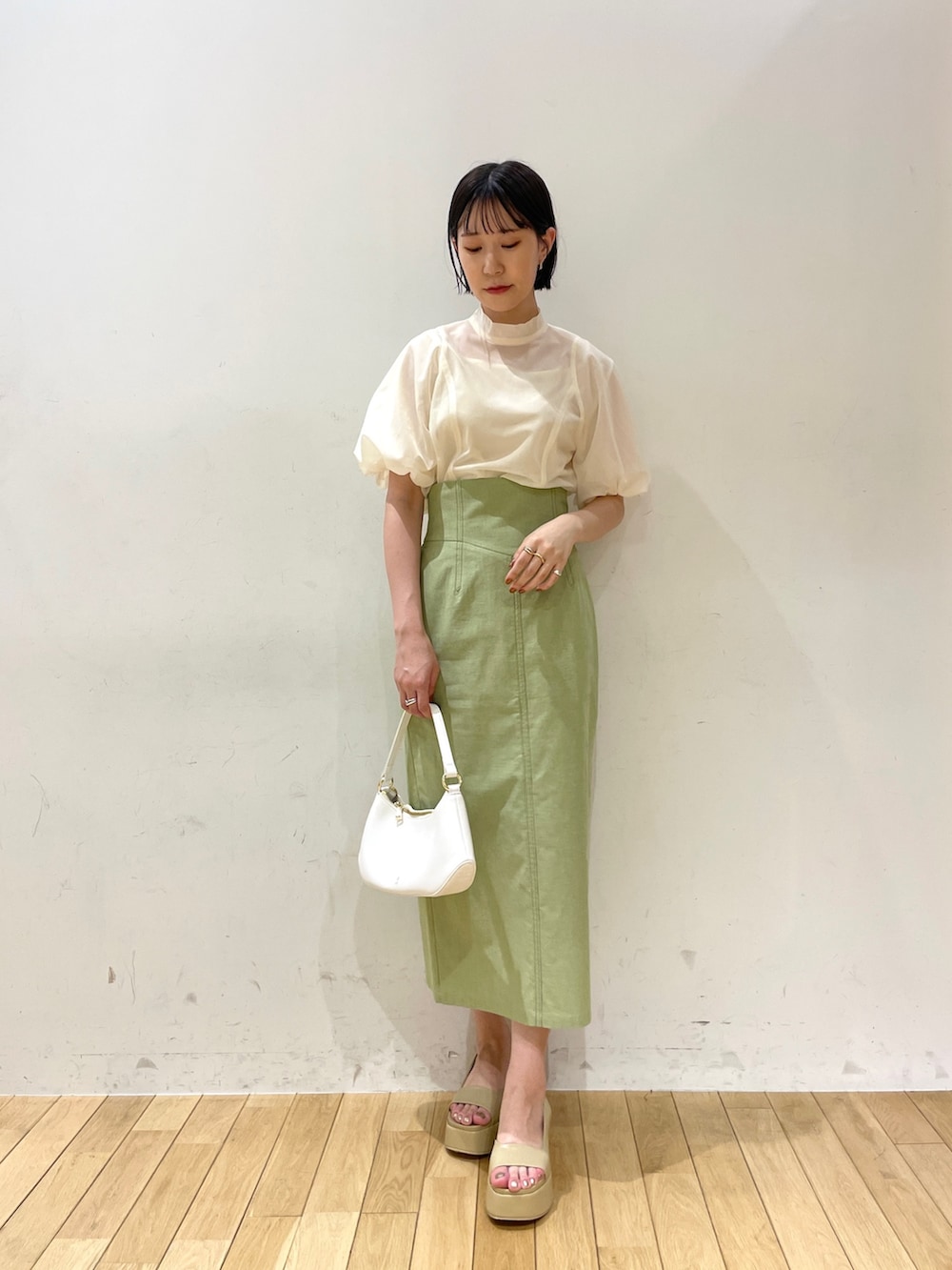 ベージュ系のサンダル、グリーン系のスカート、ホワイト系のシャツ/ブラウスを着用したレディースの夏コーディネートの2枚目の写真