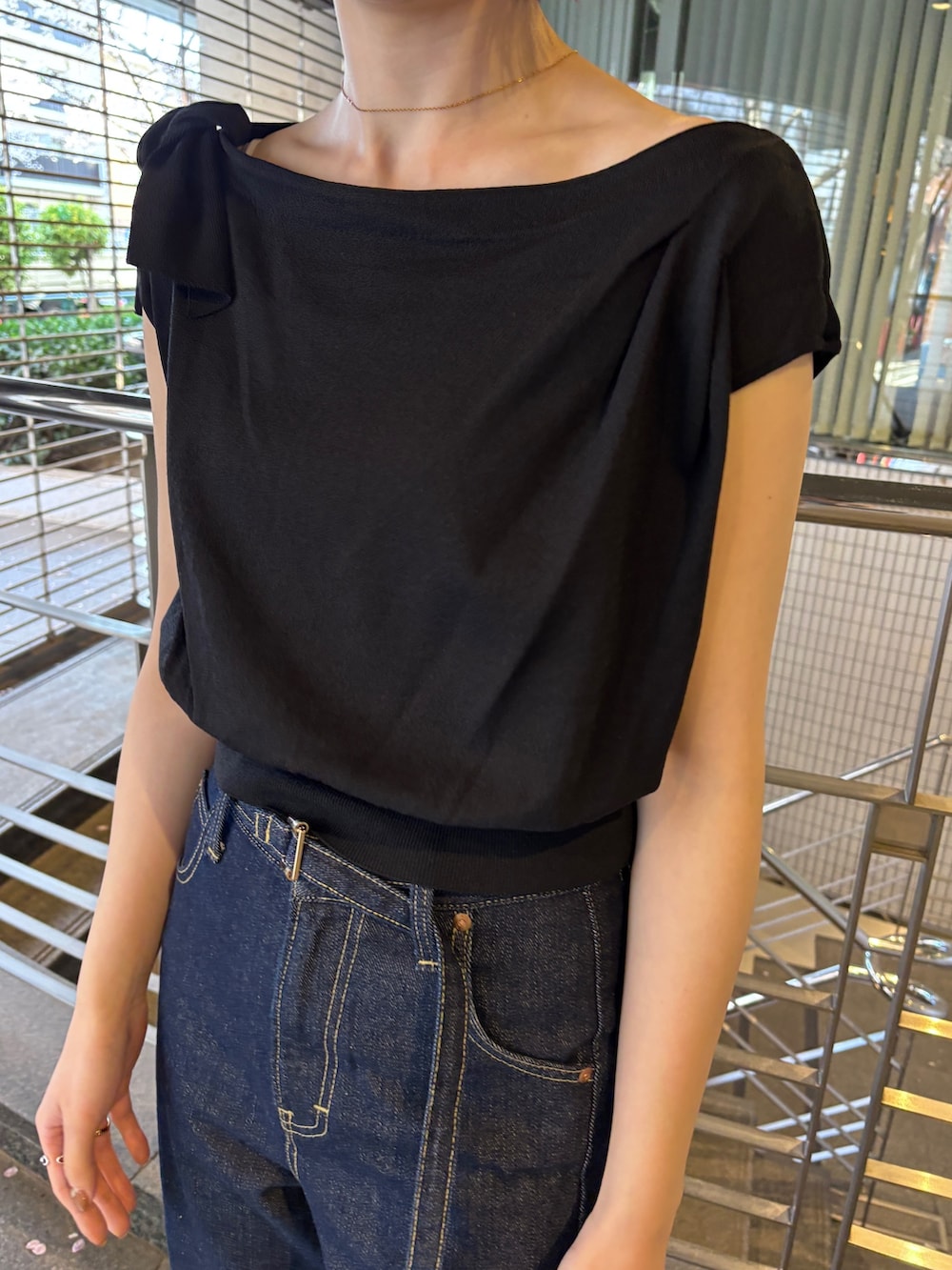 ブルー系のデニムパンツ、ブラック系のパンプス、ブラック系のニット/セーターを着用したレディースの春コーディネートの4枚目の写真