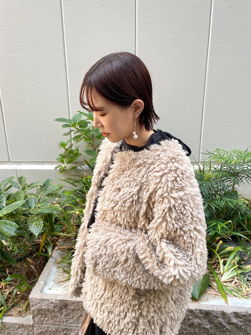 ゴールド系のハンドバッグ、その他のパンプス、ブラック系のドレスを着用したレディースの秋コーディネートの5枚目の写真