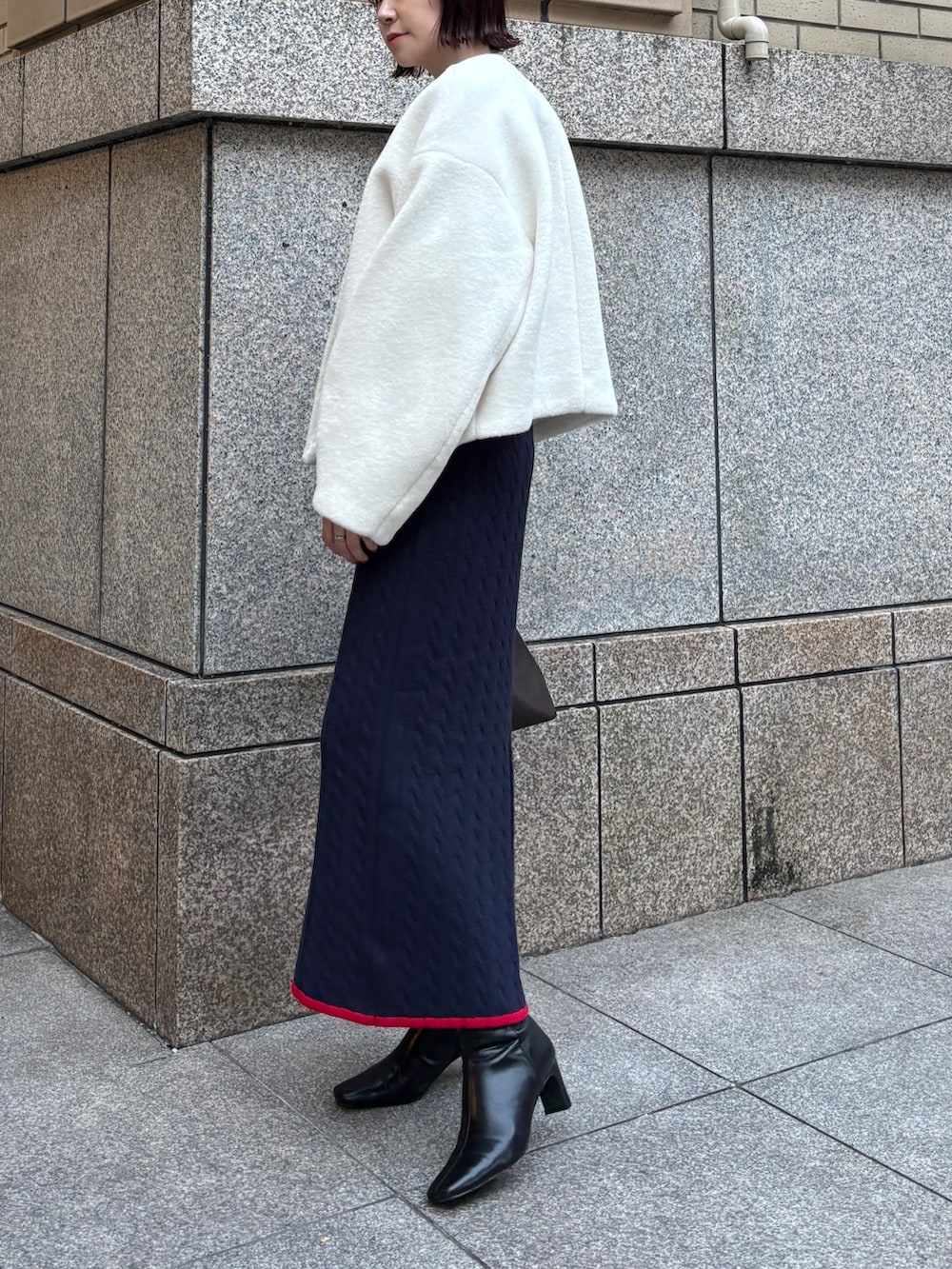 ホワイト系のブルゾン、ブルー系のワンピース、ブラウン系のボストンバッグを着用したレディースの秋コーディネートの4枚目の写真