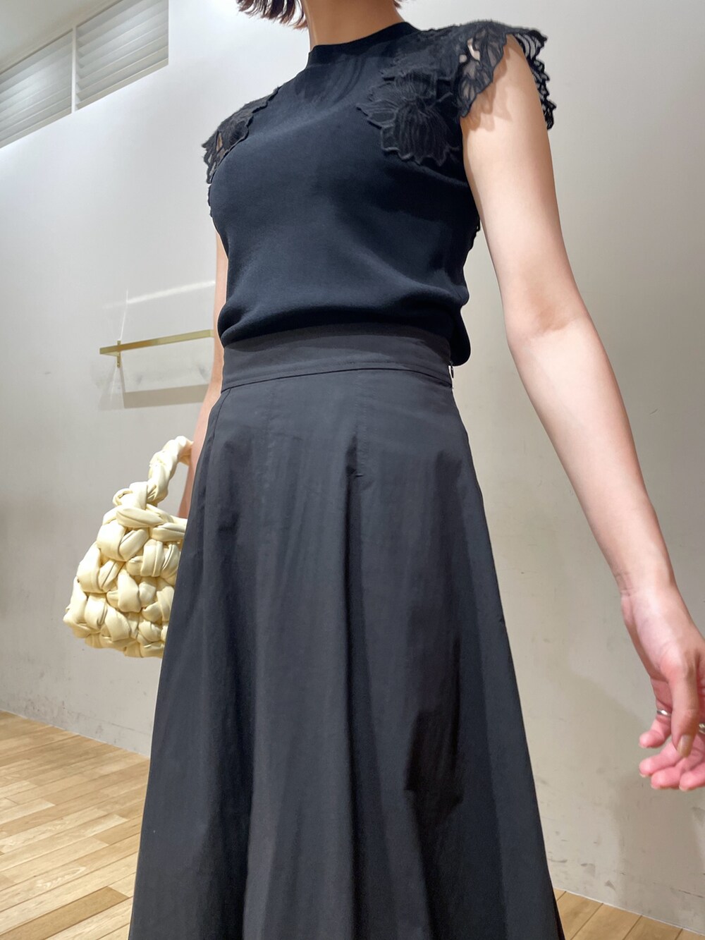 ベージュ系のハンドバッグ、ブラック系のサンダル、ブラック系のニット/セーターを着用したレディースの夏コーディネートの7枚目の写真