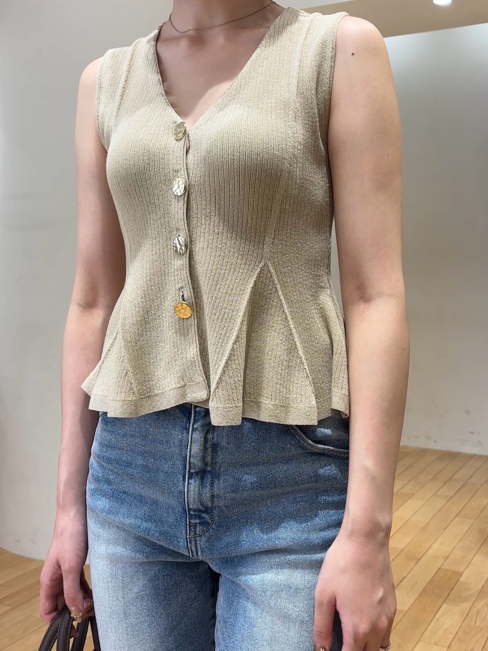 ブルー系のデニムパンツ、ブラウン系のハンドバッグ、シルバー系のパンプスを着用したレディースの夏コーディネートの5枚目の写真