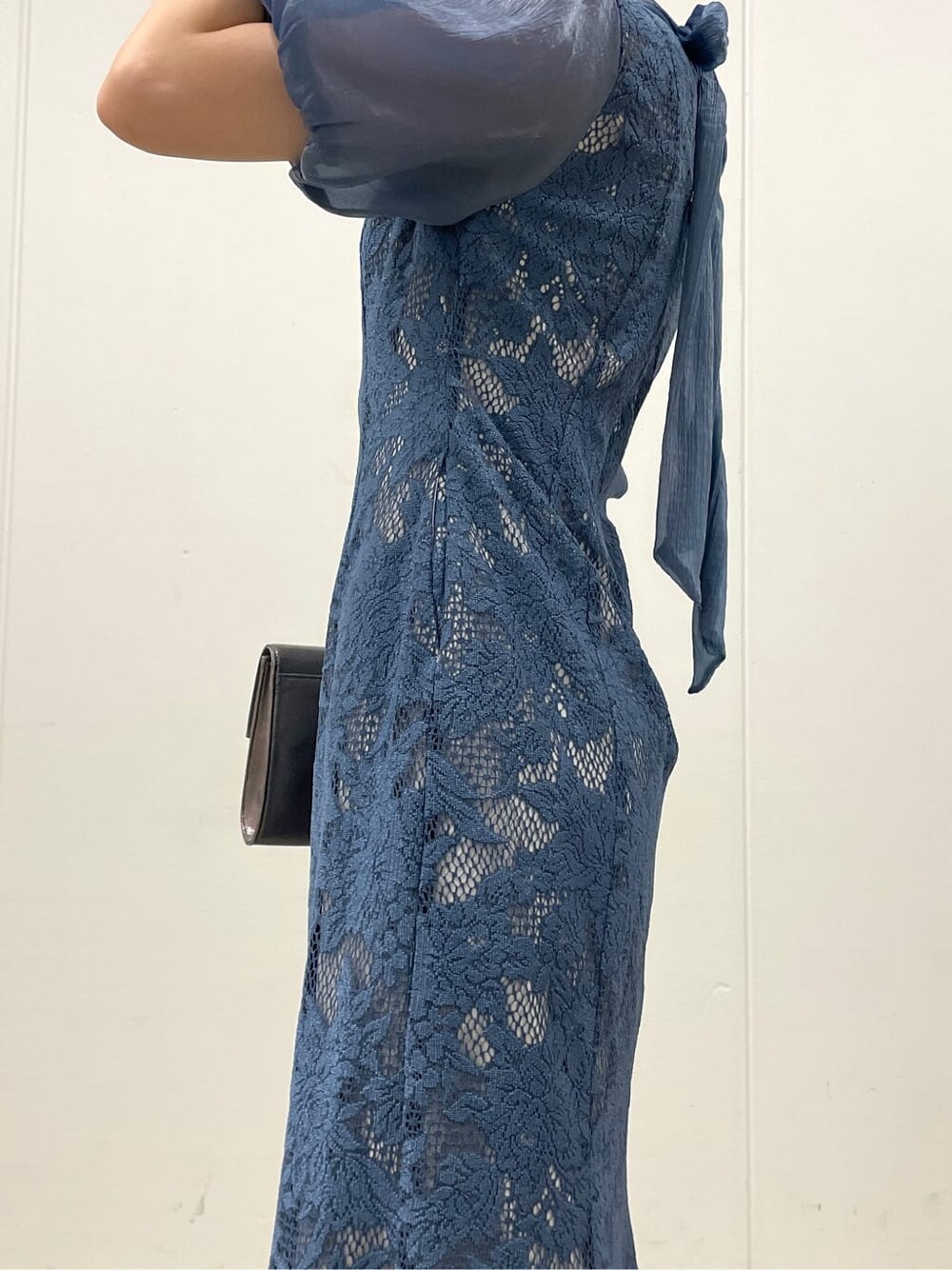 シルバー系のクラッチバッグ、ベージュ系のパンプス、ブルー系のドレスを着用したレディースの夏コーディネートの7枚目の写真