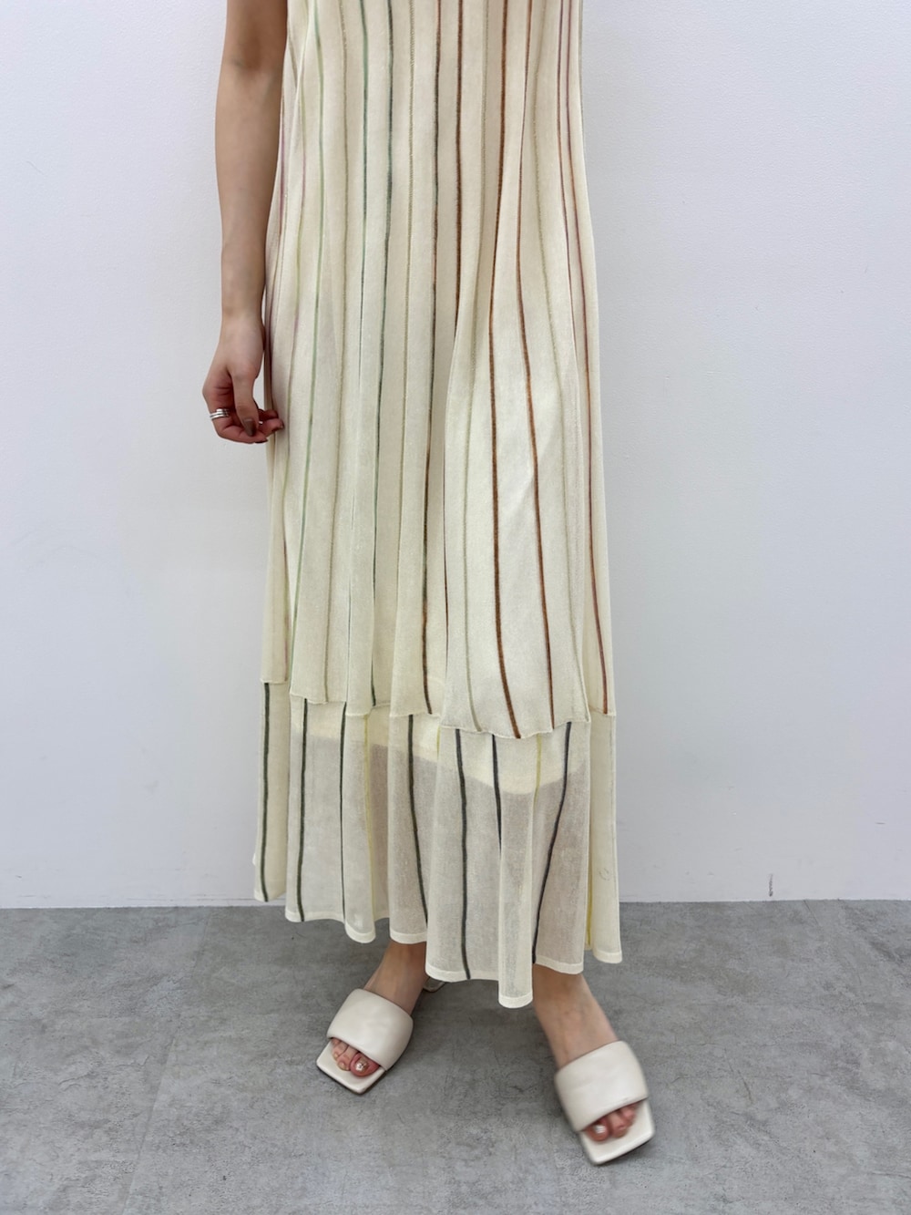 ホワイト系のワンピース、ホワイト系のサンダル、シルバー系のネックレスを着用したレディースの春コーディネートの6枚目の写真