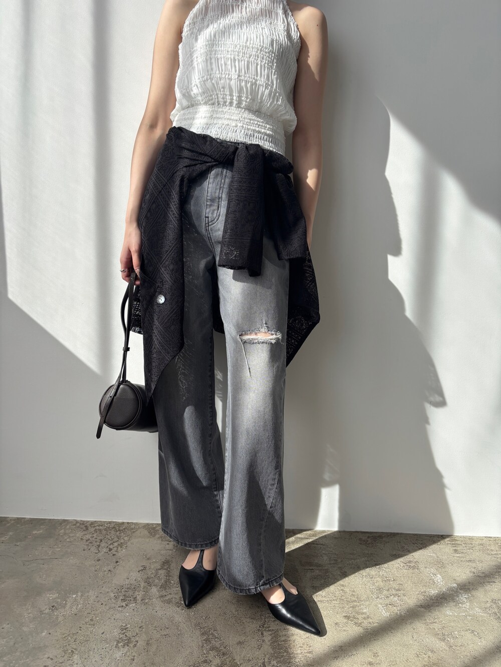 グレー系のデニムパンツ、ブラック系のパンプス、ブラック系のテーラードジャケットを着用したレディースの春コーディネートの6枚目の写真