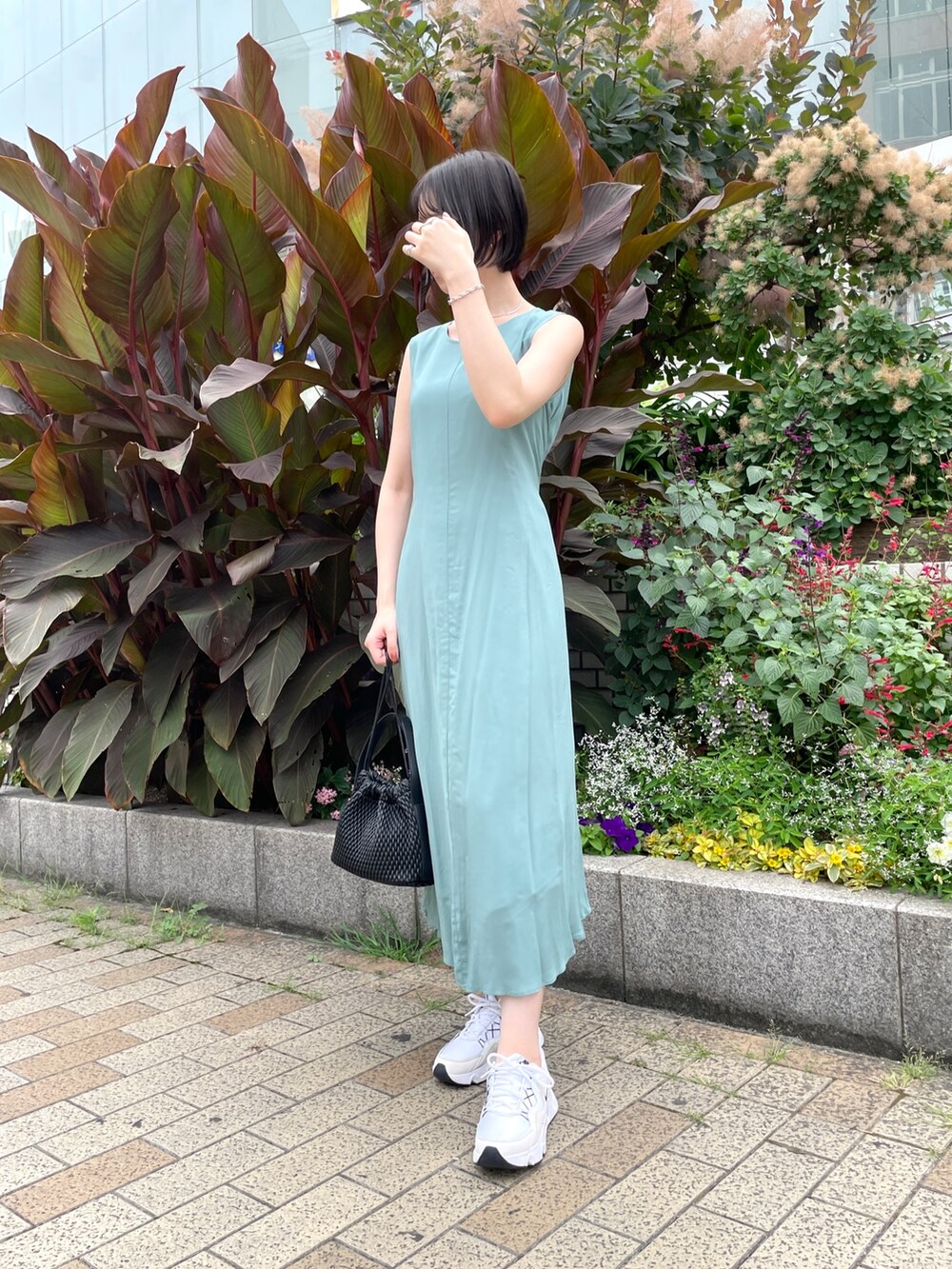 グリーン系のワンピース、ブラック系のハンドバッグを着用したレディースの夏コーディネートの6枚目の写真