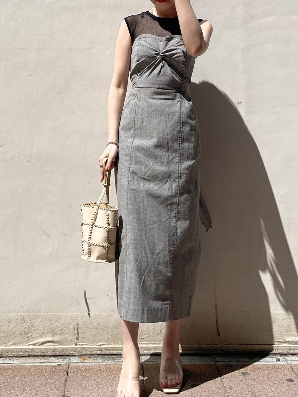 ブラック系のワンピース、その他のサンダル、ホワイト系のショルダーバッグを着用したレディースの春コーディネートの2枚目の写真