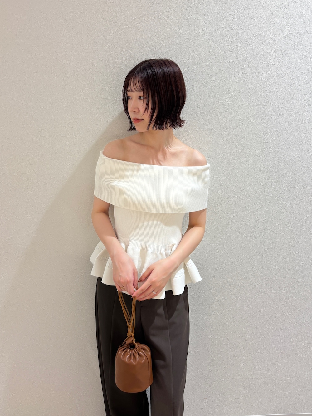ブラウン系のその他パンツ、ホワイト系のニット/セーター、イエロー系のハンドバッグを着用したレディースの夏コーディネートの4枚目の写真