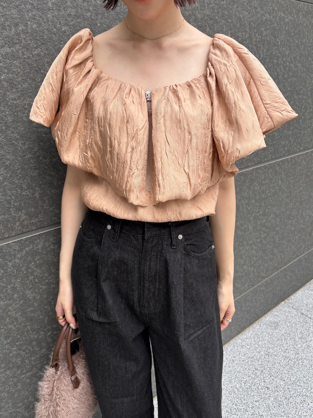 ブラック系のデニムパンツ、ブラウン系のパンプス、ブラウン系のボストンバッグを着用したレディースの夏コーディネートの6枚目の写真