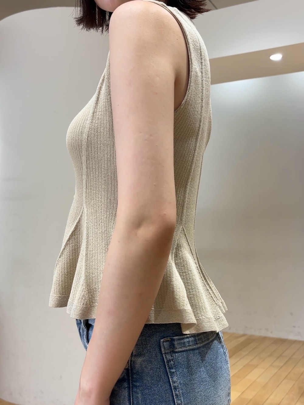 ブルー系のデニムパンツ、ブラウン系のハンドバッグ、シルバー系のパンプスを着用したレディースの夏コーディネートの6枚目の写真