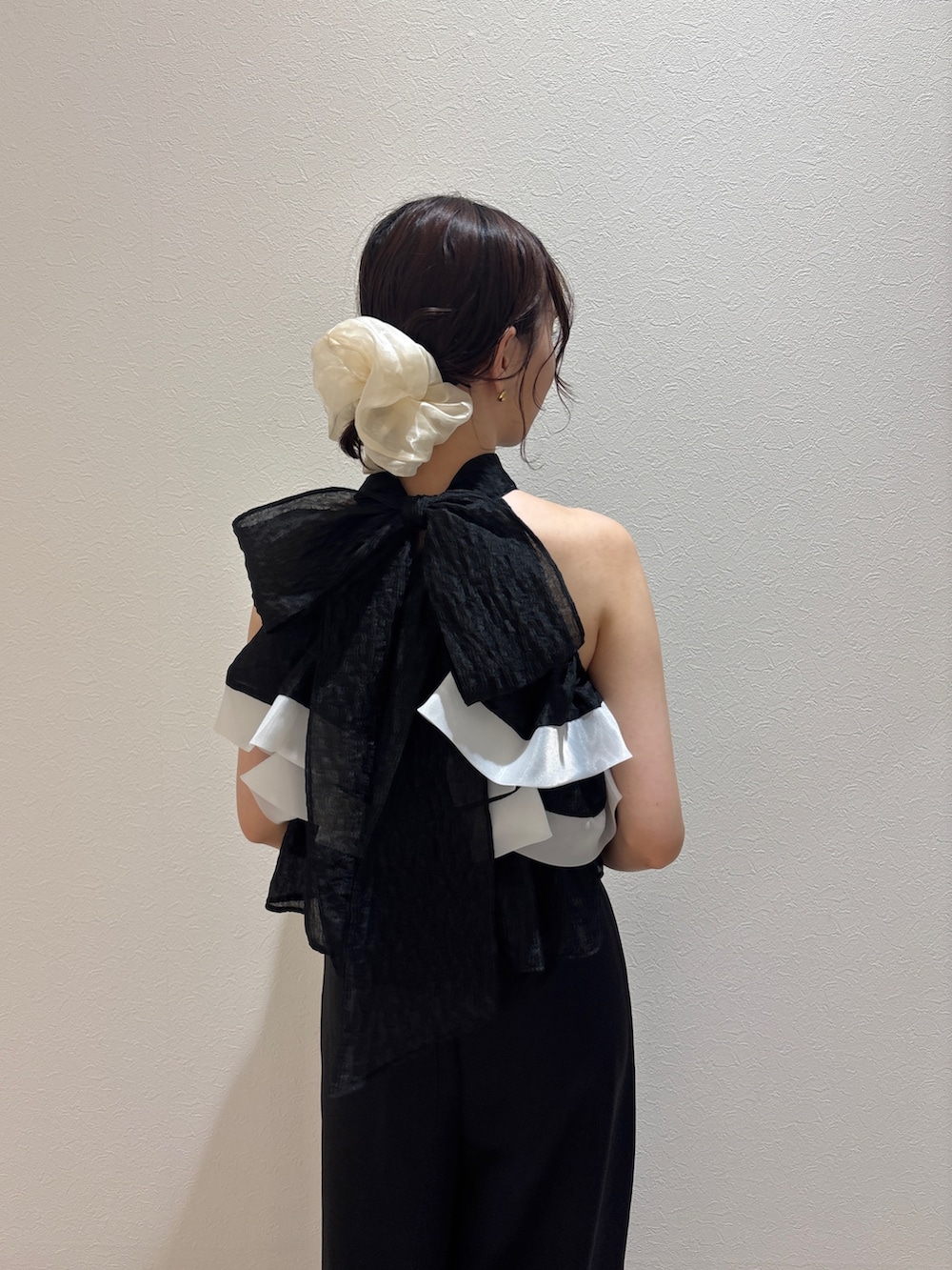 ブラック系のパンツドレス、ブラック系のハンドバッグ、ブラック系のパンプスを着用したレディースの秋コーディネートの5枚目の写真