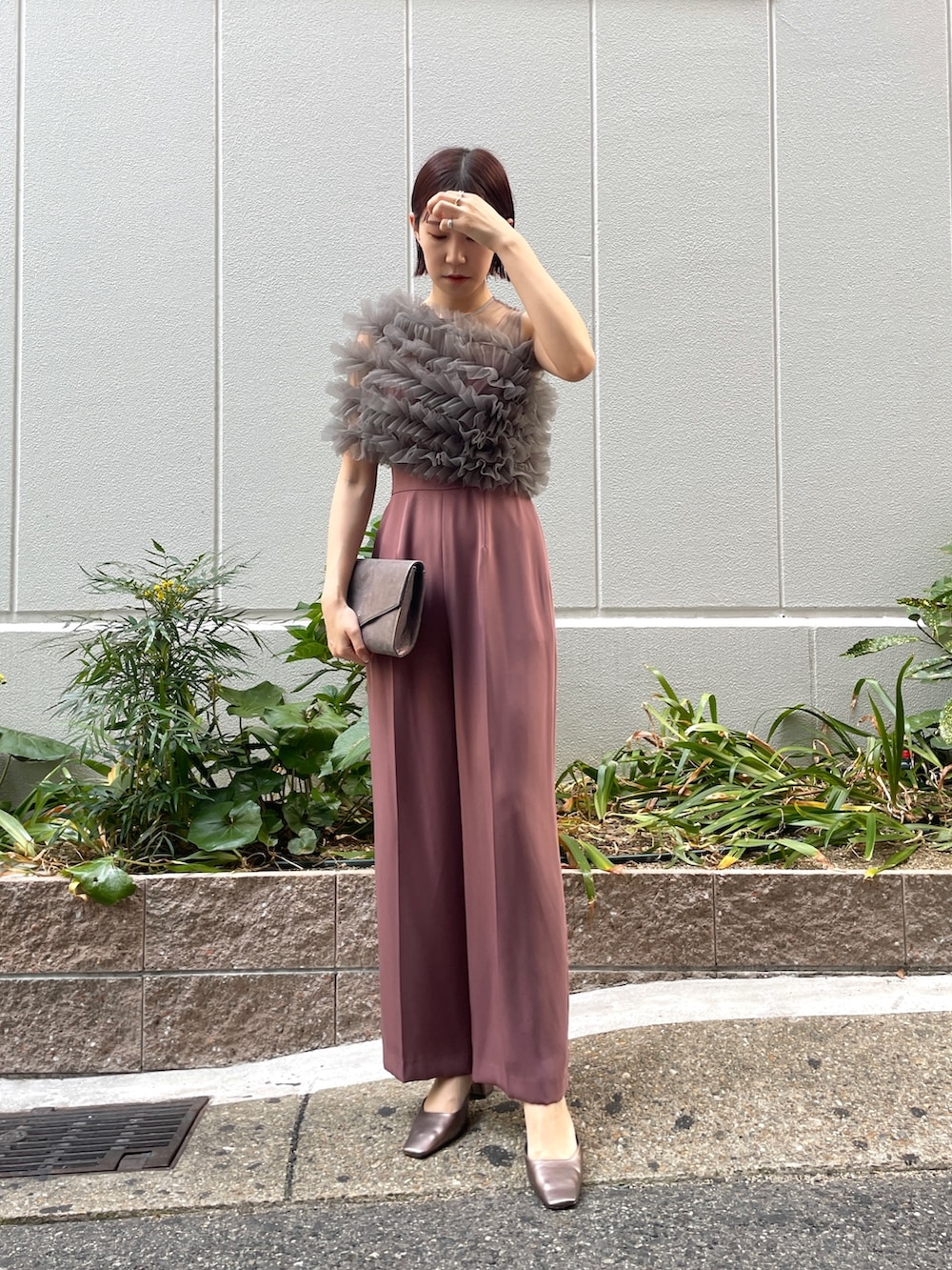 ピンク系のパンツドレス、シルバー系のハンドバッグ、その他のパンプスを着用したレディースの秋コーディネートの4枚目の写真