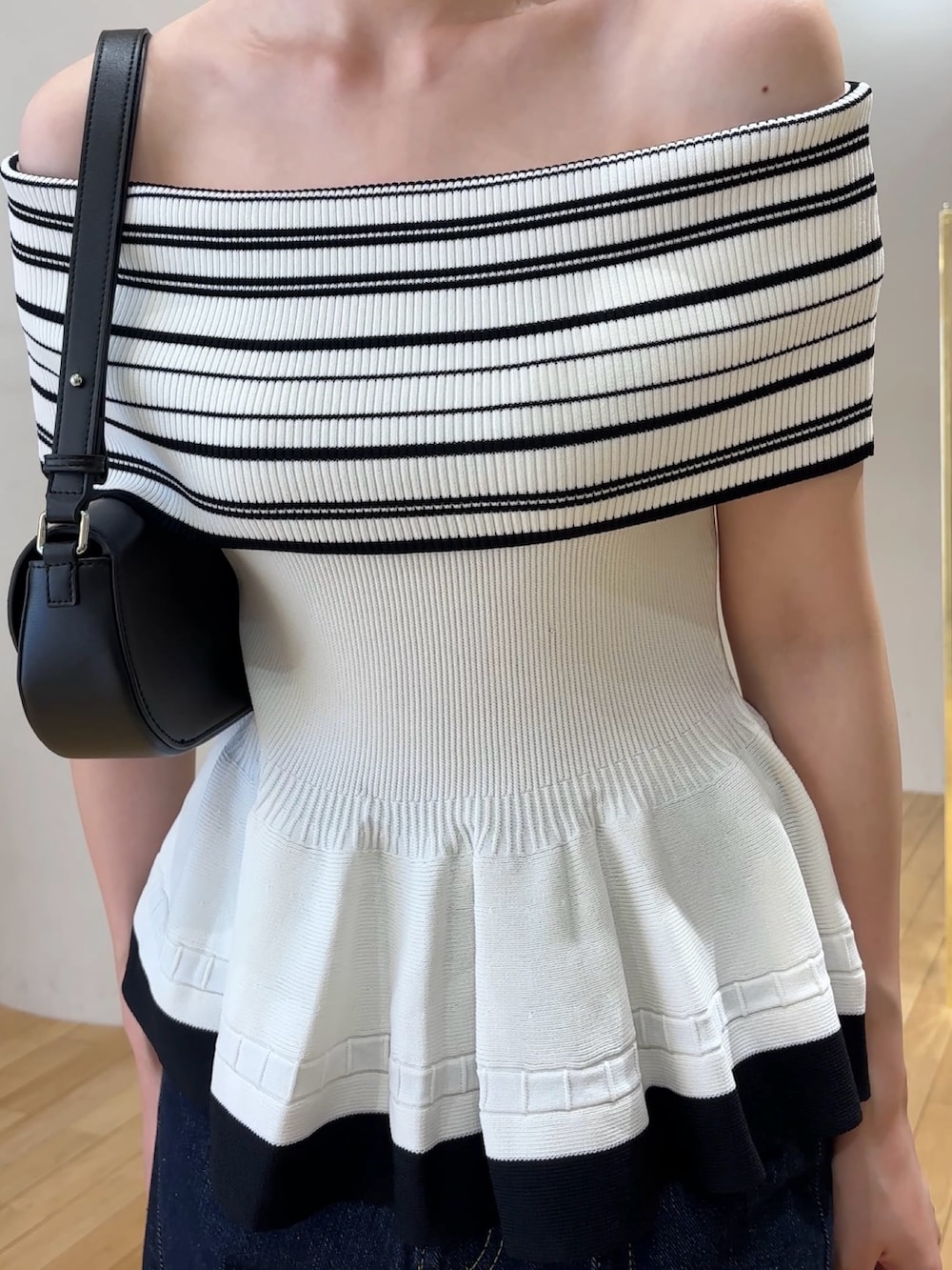 ホワイト系のニット/セーター、ブルー系のデニムパンツ、ブラック系のハンドバッグを着用したレディースの夏コーディネートの5枚目の写真