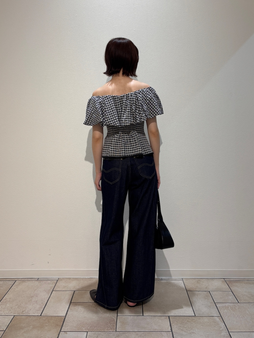 ブラック系のシャツ/ブラウス、ブルー系のデニムパンツ、ブラウン系のサンダルを着用したレディースの夏コーディネートの4枚目の写真