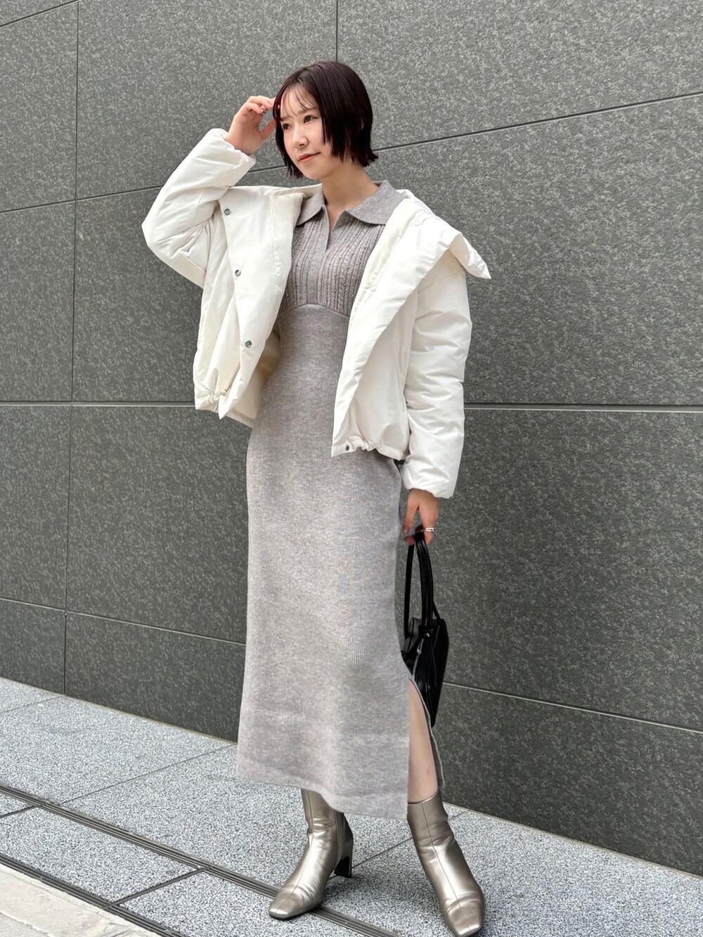 グレー系のワンピース、シルバー系のブーツ、ブラック系のショルダーバッグを着用したレディースの秋コーディネートの7枚目の写真