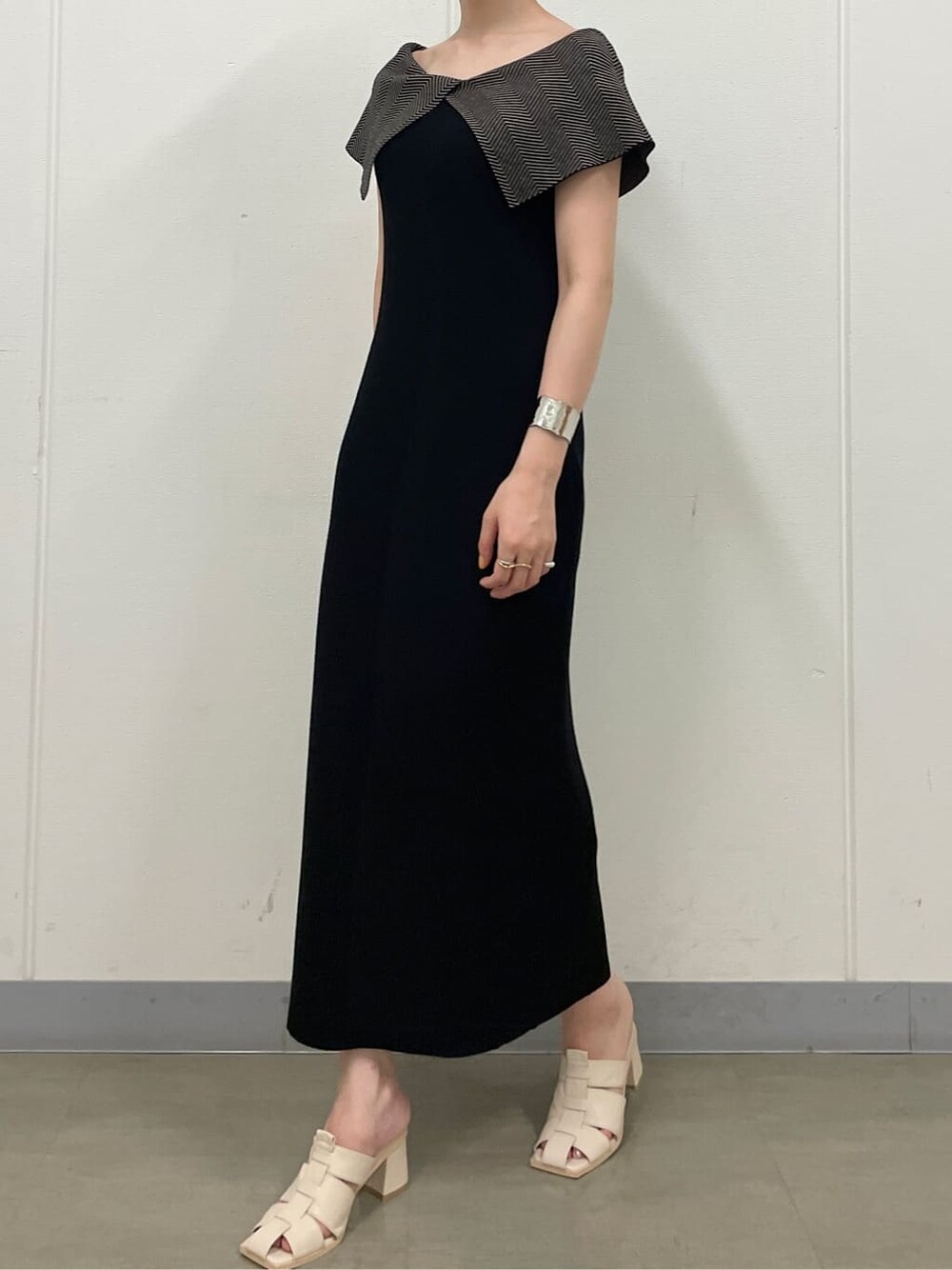 ホワイト系のサンダル、ブラック系のワンピース、シルバー系のバングル/リストバンドを着用したレディースの夏コーディネートの4枚目の写真