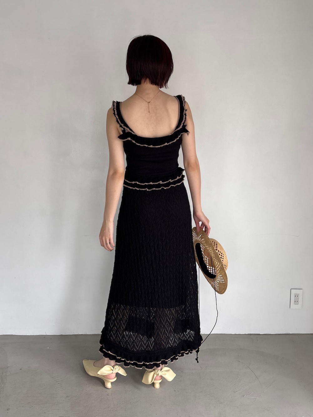 ブラック系のワンピース、イエロー系のパンプスを着用したレディースの夏コーディネートの4枚目の写真