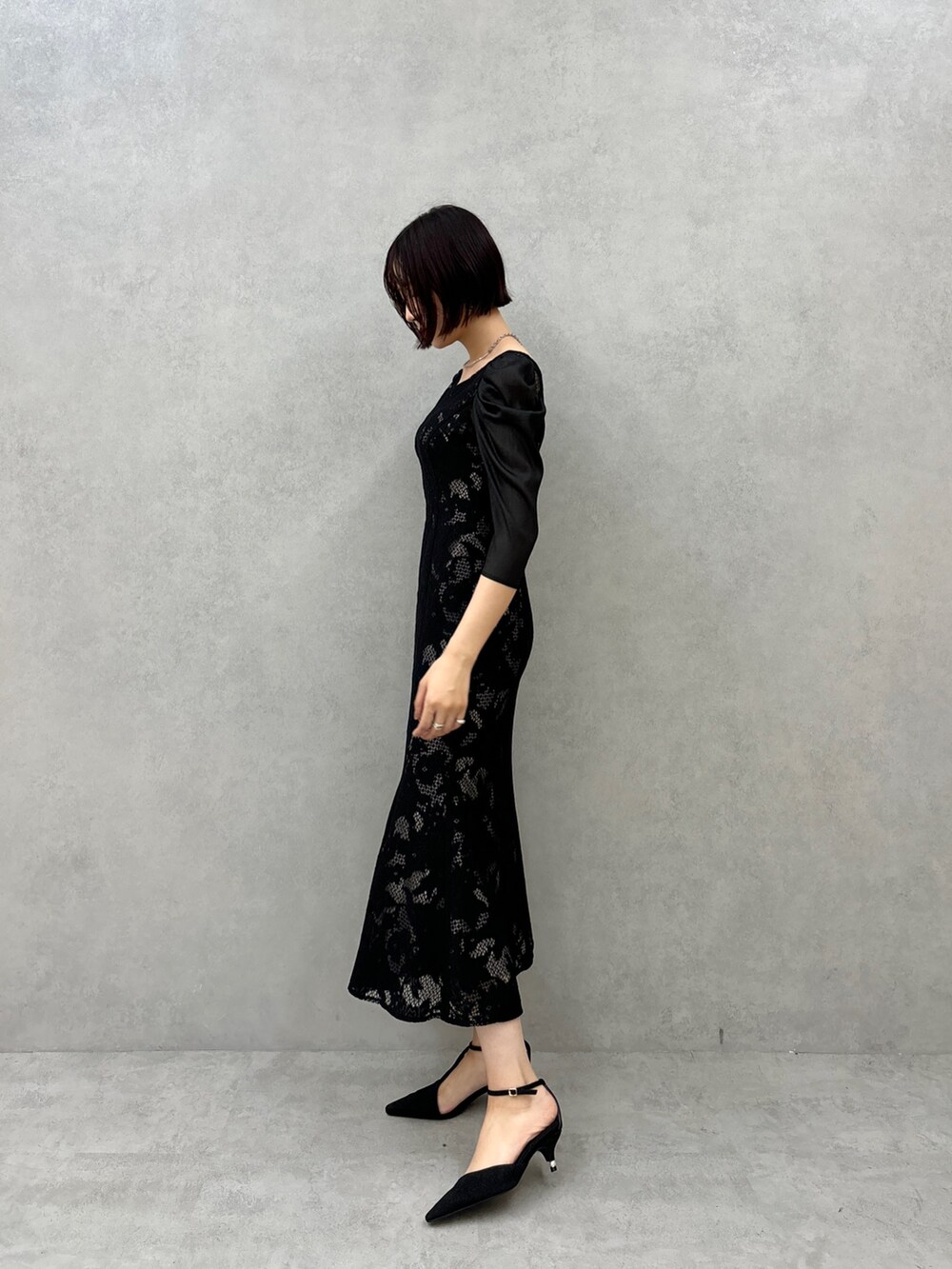 ブラック系のドレス、ブラック系のパンプスを着用したレディースの秋コーディネートの2枚目の写真