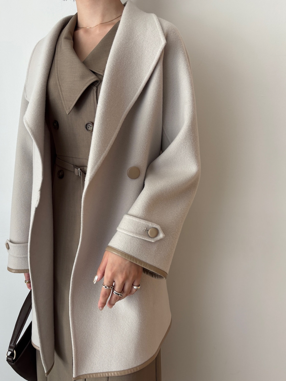 ホワイト系のワンピース、ブラウン系のブーツ、ブラウン系のハンドバッグを着用したレディースの秋コーディネートの4枚目の写真