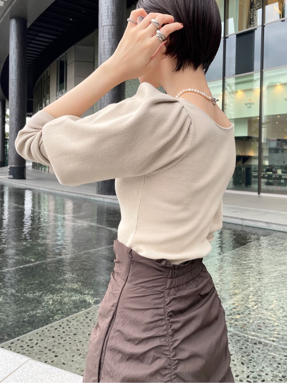 ブラック系のその他シューズ、ベージュ系のその他アウター、ブラウン系のスカートを着用したレディースの秋コーディネートの6枚目の写真