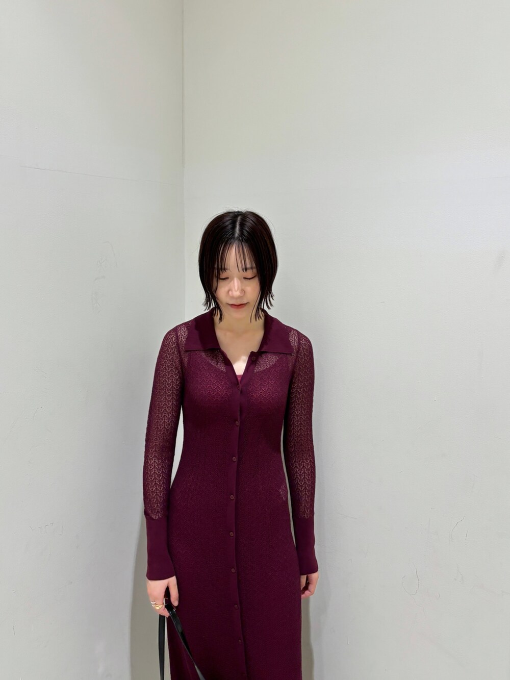 パープル系のワンピース、ブラック系のショルダーバッグ、シルバー系のブーツを着用したレディースの秋コーディネートの5枚目の写真