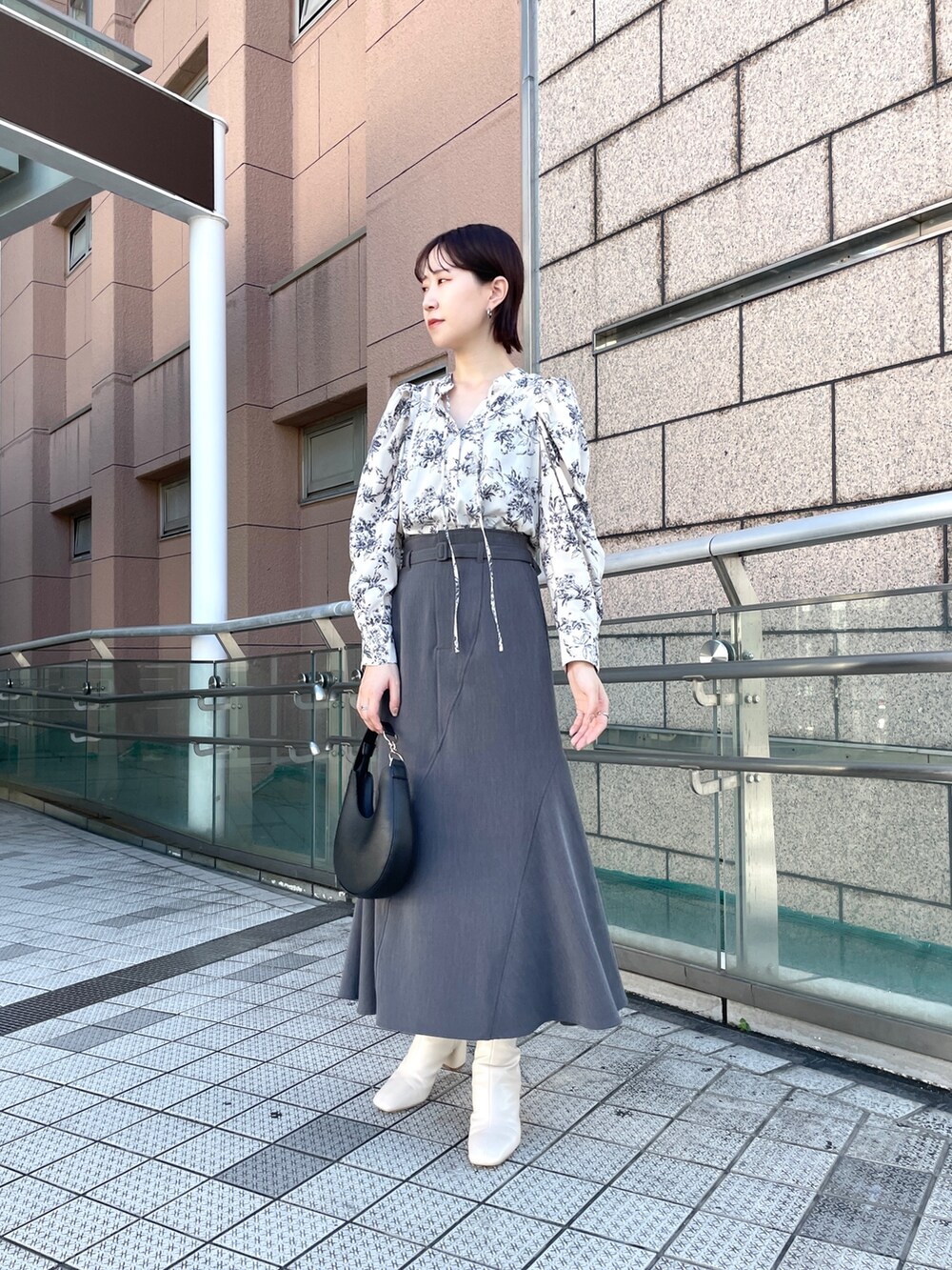 ピンク系のカーディガン/ボレロ、グレー系のスカート、ホワイト系のシャツ/ブラウスを着用したレディースの秋コーディネートの7枚目の写真