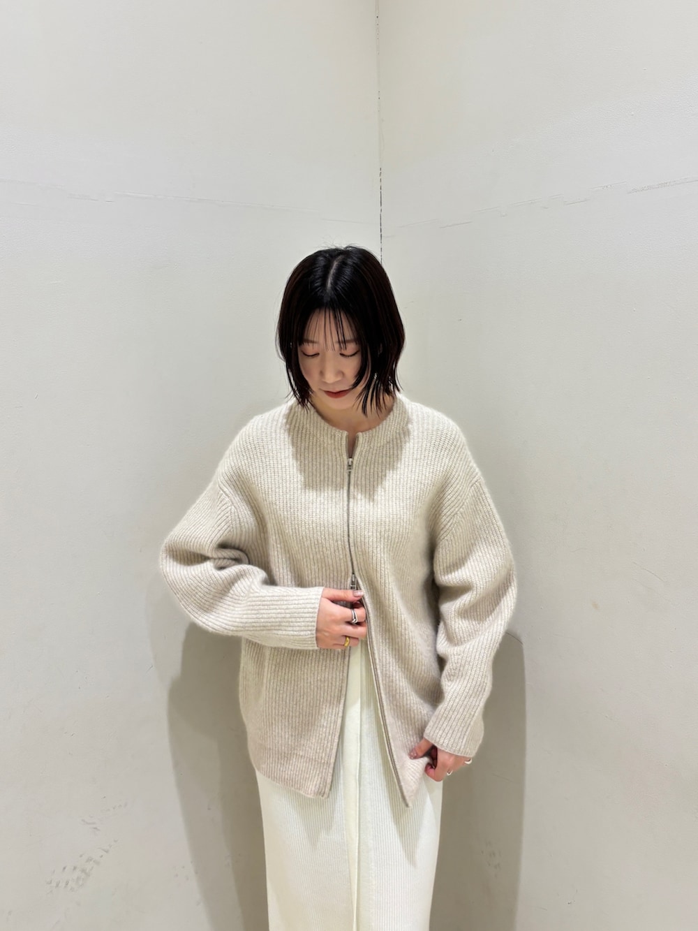 グリーン系のニット/セーター、ホワイト系のワンピース、ホワイト系のカーディガン/ボレロを着用したレディースの冬コーディネートの6枚目の写真