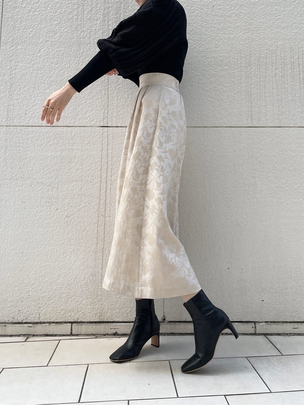 ブラック系のその他シューズ、ベージュ系のスカート、ブラック系のニット/セーターを着用したレディースの冬コーディネートの3枚目の写真