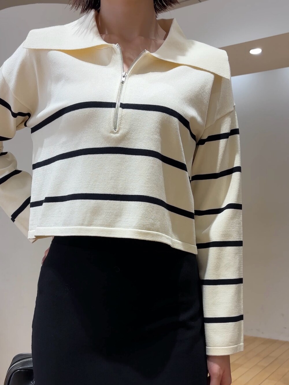 ホワイト系のニット/セーター、ブラック系のスカート、ブラック系のブーツを着用したレディースの冬コーディネートの4枚目の写真