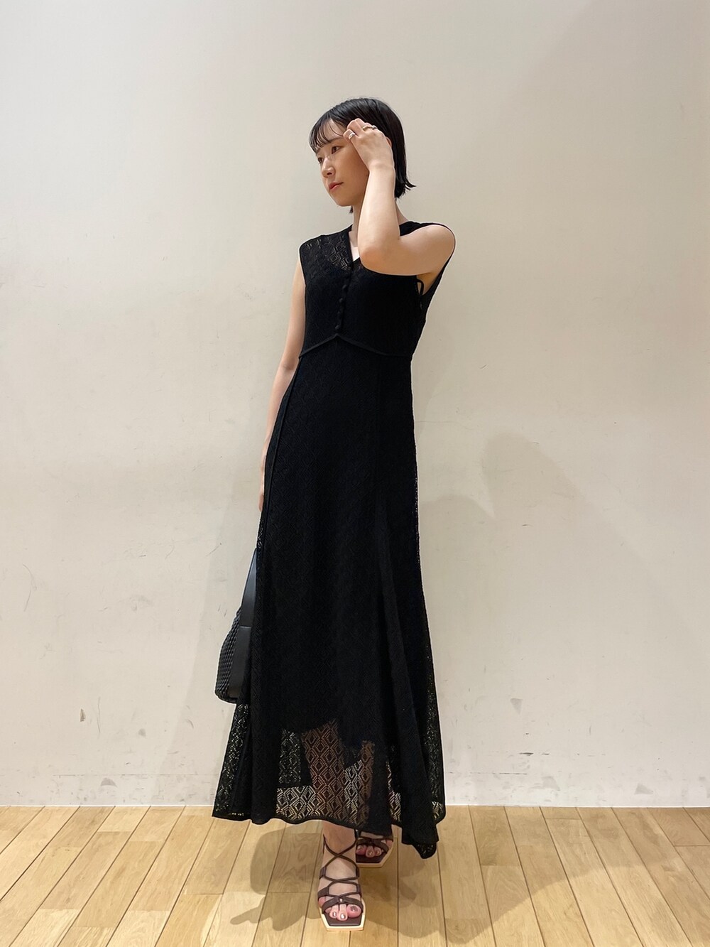 ブラック系のワンピース、ブラック系のハンドバッグ、ブラウン系のサンダルを着用したレディースの夏コーディネートの2枚目の写真