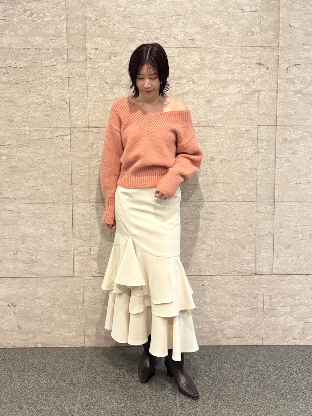 ピンク系のニット/セーター、ブラウン系のブーツ、ホワイト系のスカートを着用したレディースの冬コーディネートの7枚目の写真