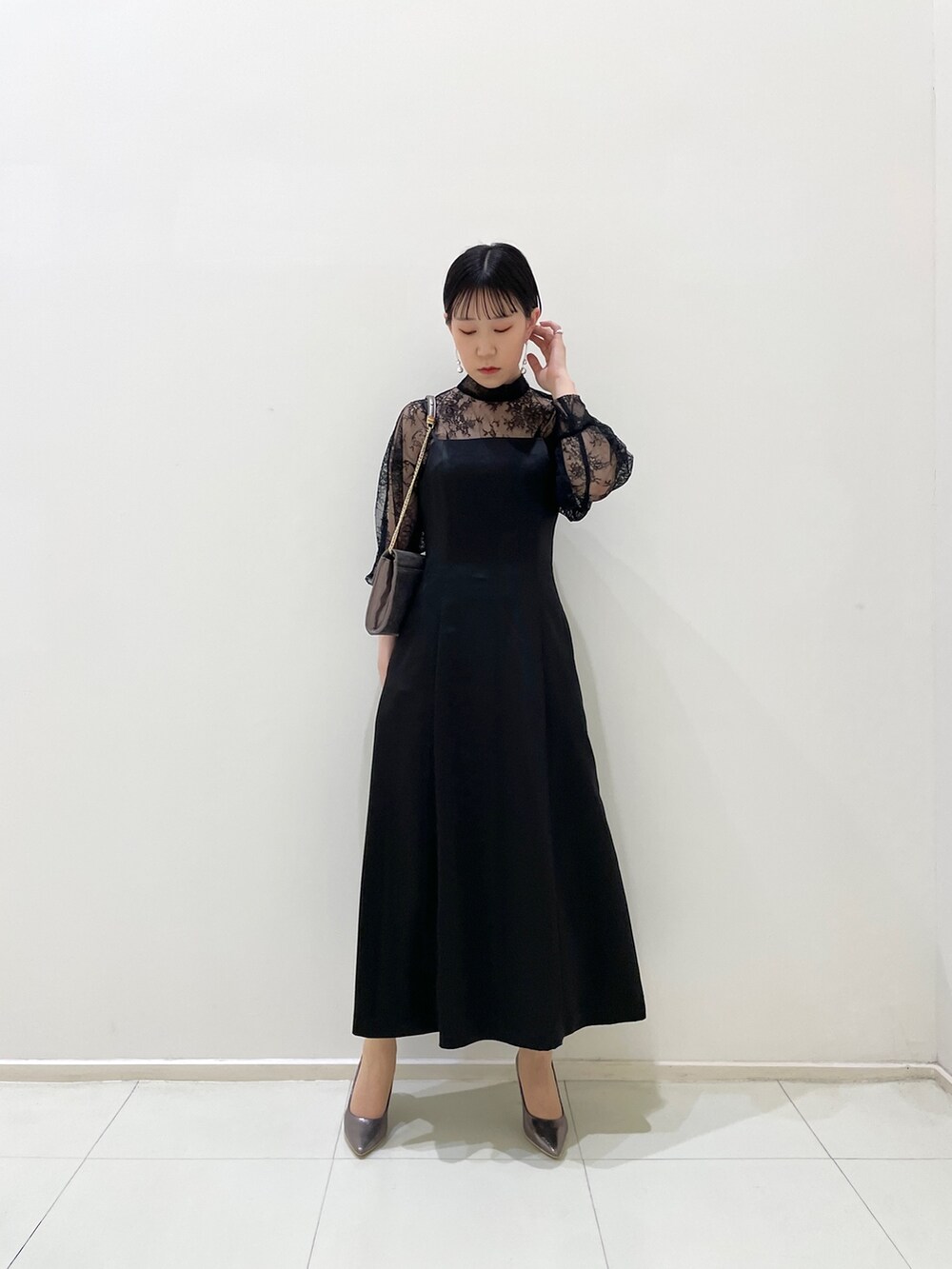 ブラック系のドレス、シルバー系のパンプス、シルバー系のハンドバッグを着用したレディースの春コーディネートの7枚目の写真