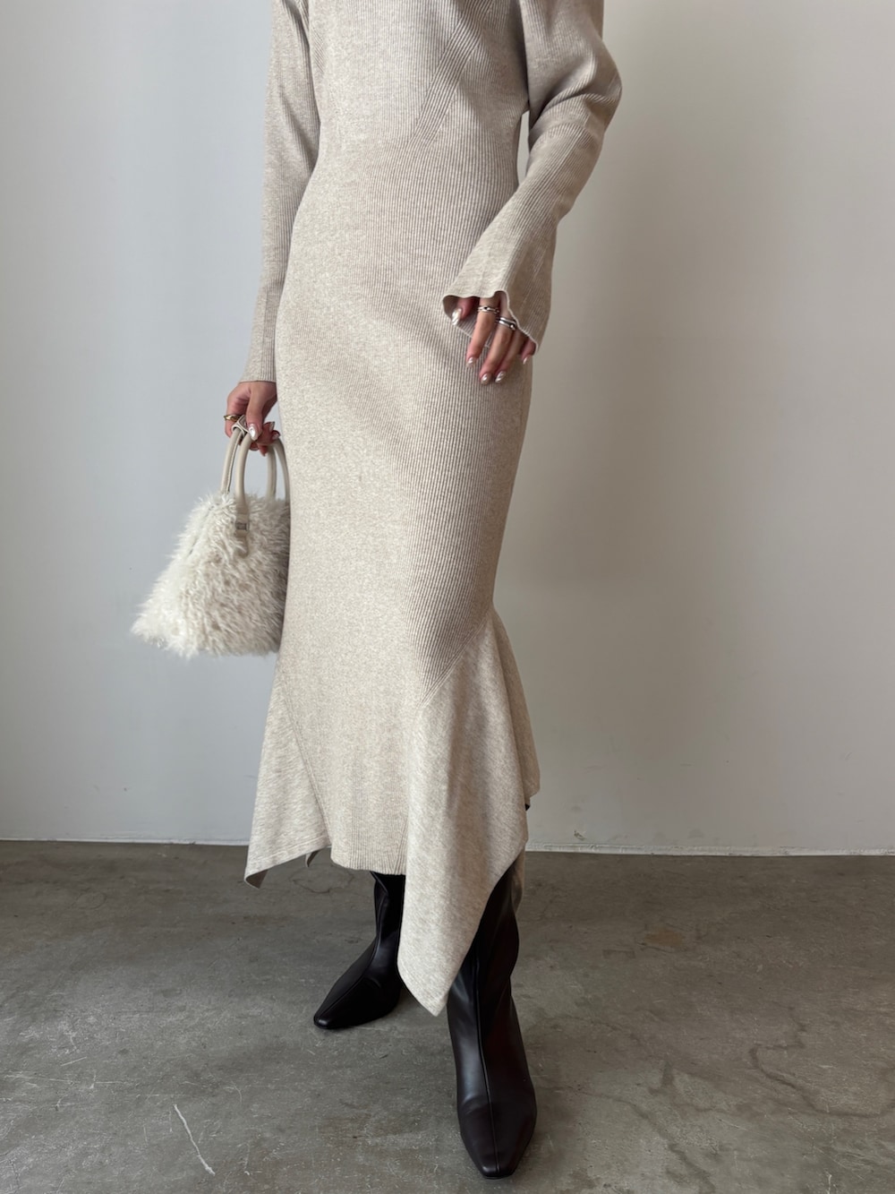 ベージュ系のワンピース、ホワイト系のボストンバッグ、ブラウン系のブーツを着用したレディースの秋コーディネートの4枚目の写真