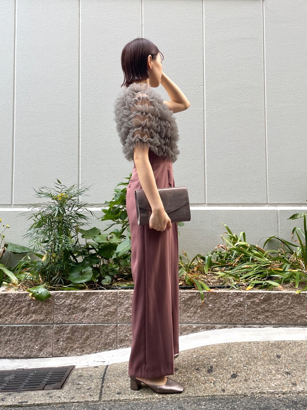 ピンク系のパンツドレス、シルバー系のハンドバッグ、その他のパンプスを着用したレディースの秋コーディネートの5枚目の写真